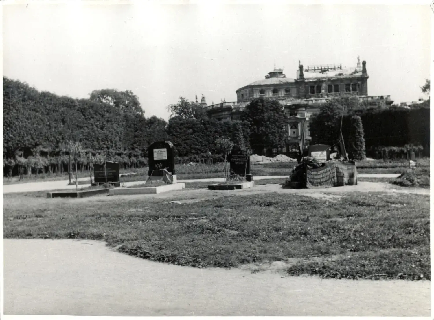 Stunde Null: Gräber sowjetischer Soldaten im Volksgarten, dahinter Kriegsschäden am Burgtheater, 1945, anonyme Fotografie, Wien Museum