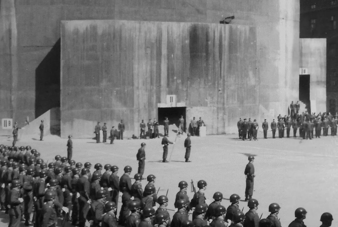 Im April 1948 fanden im Hof der Stiftskaserne Feierlichkeiten zum „Tag der Armee“ statt. Dabei entstand dieses Foto, das die wehende Flagge der USA und die noch immer sehr gut sichtbaren Eingangsbezeichnungen am Flakturm zeigt (siehe Ausschnitt unterhalb). Quelle: Archiv des Bezirksmuseums Neubau