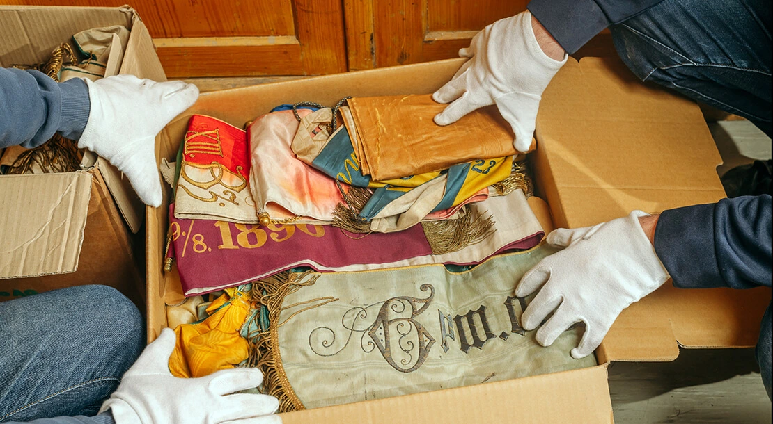 Für Jahrzehnte waren manche Konvolute in Kisten verstaut. Etwa diese Sammlung an Fahnenbändern im Bezirksmuseum Penzing. Nun wird diese fachmännisch sortiert und einzeln verpackt.  