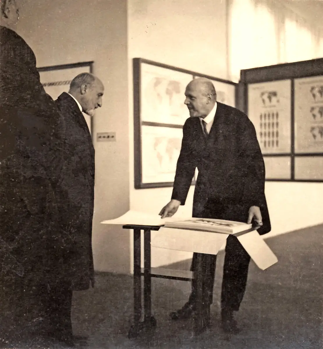 Otto Neurath präsentiert Bürgermeister Karl Seitz das Mappenwerk „Gesellschaft und Wirtschaft“ während der Eröffnung der Ausstellung „Weltwirtschaft“ in den Räumen des Museums im Fuchsenfeldhof, Oktober 1930; Otto and Marie Neurath Isotype Collection, University of Reading  