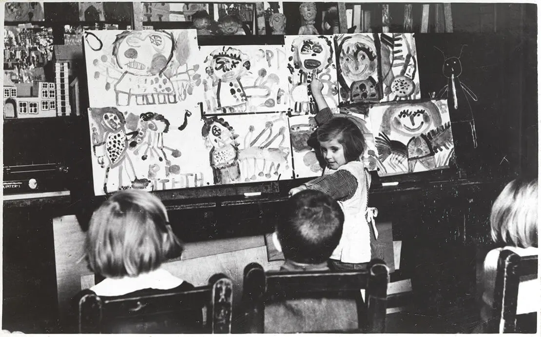 Ein Mädchen der Jugendkunstklasse präsentiert den Mitschüler_innen ihre Arbeit, Fotografie von Rudolf Johann Bohl, 1934, Wien Museum  