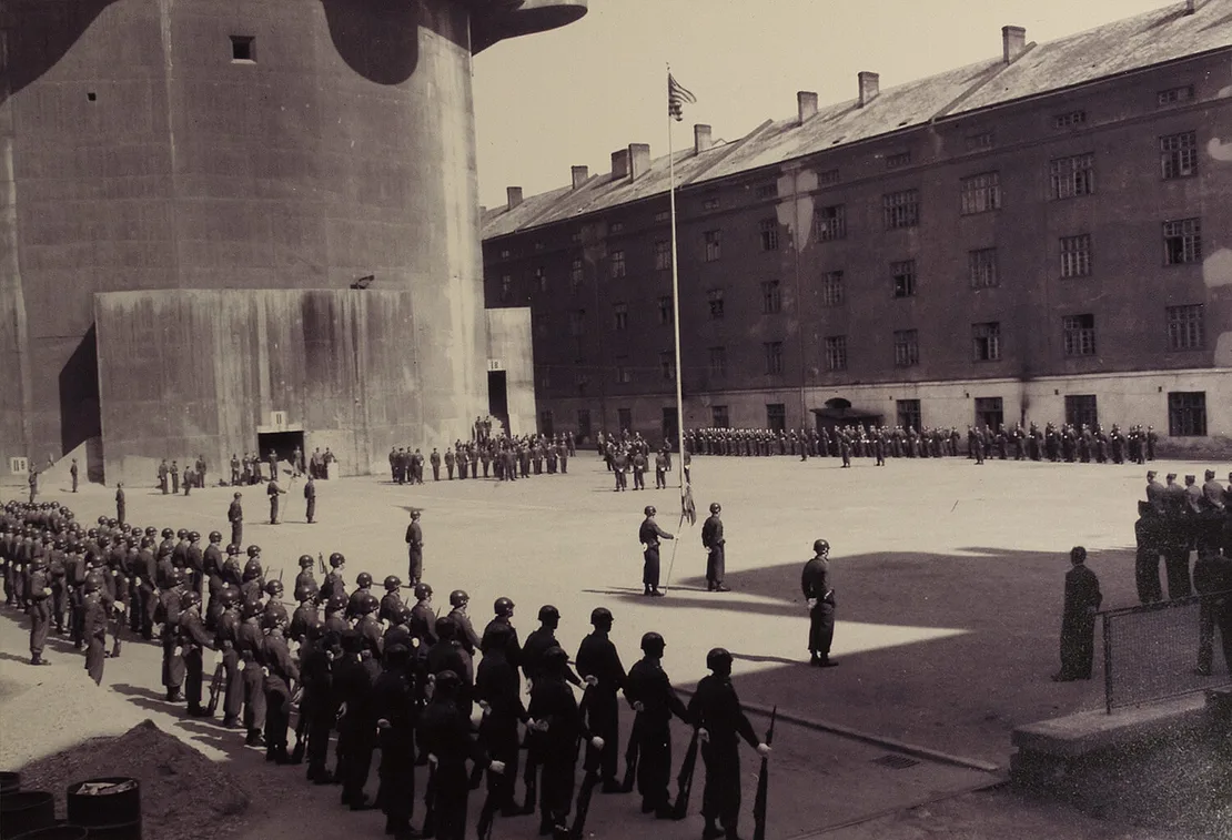 Im April 1948 fanden im Hof der Stiftskaserne Feierlichkeiten zum „Tag der Armee“ statt. Dabei entstand dieses Foto, das die wehende Flagge der USA und die noch immer sehr gut sichtbaren Eingangsbezeichnungen am Flakturm zeigt (siehe Ausschnitt unterhalb). Quelle: Archiv des Bezirksmuseums Neubau