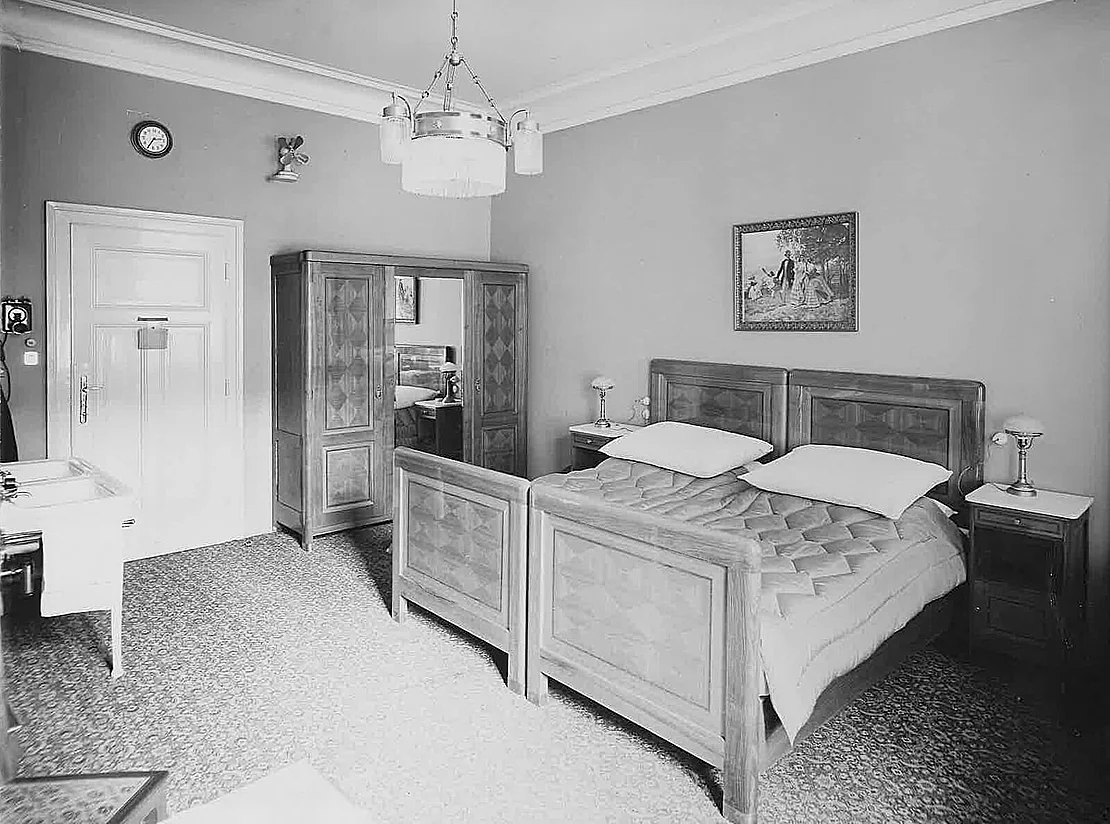 Gästezimmer mit elektrischer Beleuchtung, Telefon, Wanduhr und Ventilator, 1920er-Jahre, Verkehrsbüro/Hotel Astoria  