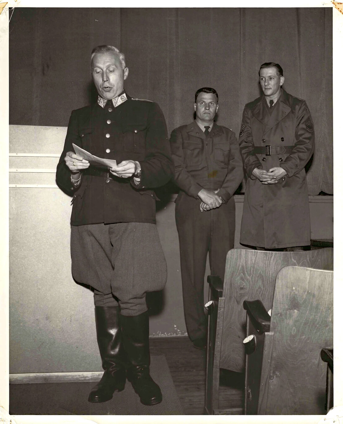 Sicherheitsunterweisung für österreichische Fahrer der US Streitkräfte in Österreich beim Benutzen US-amerikanischer Militärfahrzeuge durch Oberst Gustav Hauck, Polizei, Salzburg, 19. Dezember 1953. Rechts Capt. Ralph Carel, Standort- Kommandant der US-Streitkräfte für motorisierte Fahrzeuge, rechts außen Helmut Braunsteiner in der Funktion als Sicherheitsoffizier (S-1301-1/USFA-53-19 DCT 53, US ARMY PHOTOGRAPH, MATSUNGA; SIG PHOTO SEC USFA); (Nachlass Helmut Braunsteiner)
