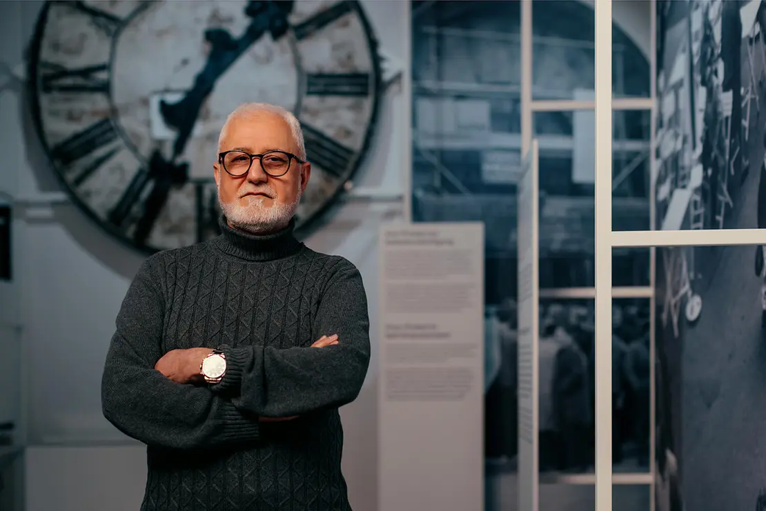 Ismail Yasin in der Dauerausstellung vor dem Ziffernblatt der Rauchfangkehrerkirche, Foto: Victoria Nazarova  