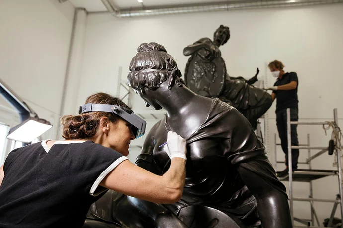 Restauratorin Ulrike Rossmeissl und Restaurator Wolfgang Schwarzkogler (im Hintergrund) bei ihrer Arbeit an den originalen Figuren des Donnerbrunnens, Foto: Ina Aydogan