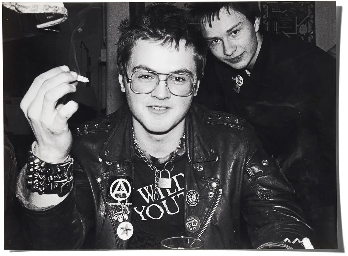 „Da sieht man im Hintergrund den Mofa und im Vordergrund den Bruder vom Roli Rotzig (dem Sänger der Band ´Terror Alarm`), den Roman aka Rawman, Schlagzeuger bei `Totes Kind`. Sein Bruder hat ihn schon mit 10 Jahren zu den Punks mitgenommen. Das Bild ist in unserem Punk-Club, im ´La Boheme`. Ich weiß nicht, wer als erster diese Lokal entdeckt hat. Vielleicht der Robert Räudig von den Chuzpe oder der Wolfgang Strobl von Dum Dum Records.“  