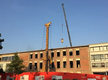 Der historische Aufzug des Oswald Haerdtl-Gebäudes wird per Kran ausgebracht - um später an anderer Stelle wieder eingebaut zu werden. Foto: Konstanze Schäfer