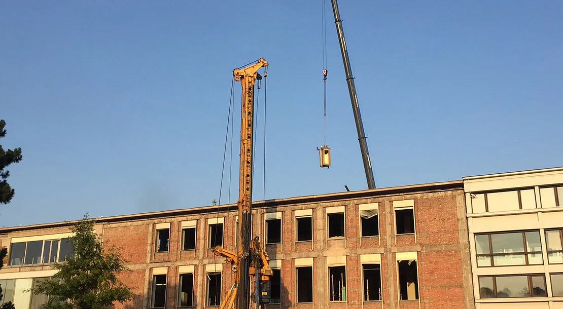 Der historische Aufzug des Oswald Haerdtl-Gebäudes wird per Kran ausgebracht - um später an anderer Stelle wieder eingebaut zu werden. Foto: Konstanze Schäfer