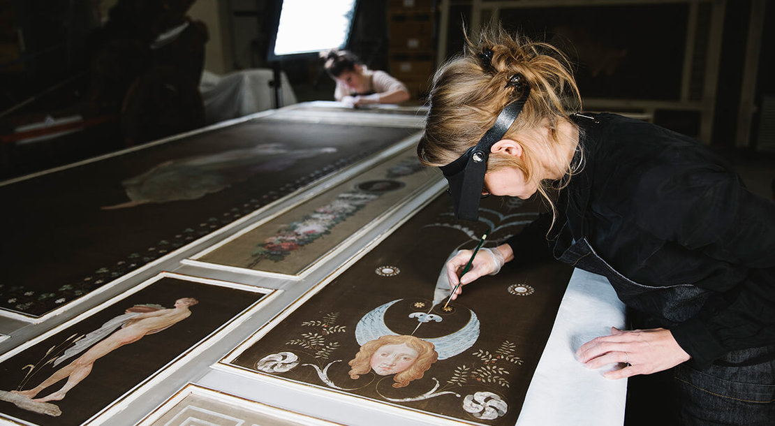 Restauratorin Christina Kapeundl bei der Arbeit an der filigranen Seidenmalerei des Pompejanischen Salons, Foto: Ina Aydogan 