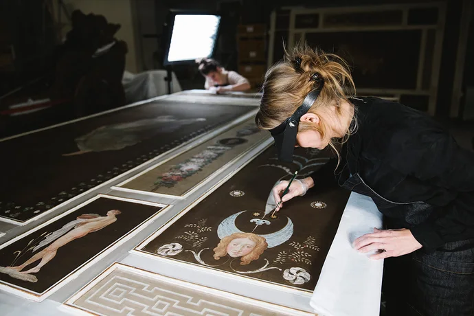 Restauratorin Christina Kapeundl bei der Arbeit an der filigranen Seidenmalerei des Pompejanischen Salons, Foto: Ina Aydogan