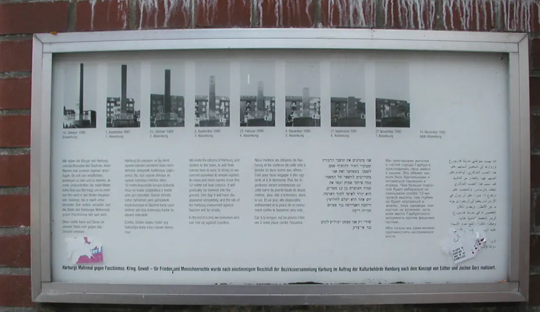 Esther und Jochen Gerz` Mahnmal gegen Faschismus, Krieg, Gewalt, für Frieden und Menschenrechte in Hamburg, 1986. Das Konzept sah eine Versenkung der 12 Meter hohen Stele vor: „Wir laden die Bürger von Harburg und die Besucher der Stadt ein, ihren Namen hier unseren eigenen anzufügen. Es soll uns verpflichten, wachsam zu sein und zu bleiben. Je mehr Unterschriften der zwölf Meter hohe Stab aus Blei trägt, um so mehr von ihm wird in den Boden eingelassen.“ Seit 1993 ist das Denkmal im Boden versenkt, rund 70.000 Namen, Eintragungen und Graffiti wurden verzeichnet. Diese Fotodokumenation des Versinkens der Stele ist heute vor Ort zu sehen. Foto: Diagram Lajard/Wikimedia Commons  