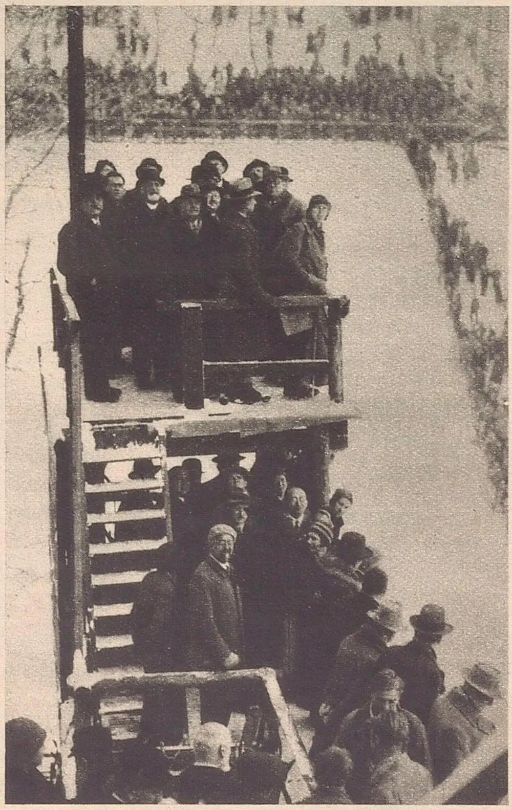 Die Ehrengäste am Beobachtungsturm. Sehr gut ist auf diesem Bild die Weite der Anlage zu erkennen sowie die im Vergleich zu dem Bild von 1929 durchgeführte Absicherung des Zuschauerbereichs mit Holzabsperrungen, „Der Kuckuck“, 21. Jänner 1934, S. 5, ANNO/ÖNB  