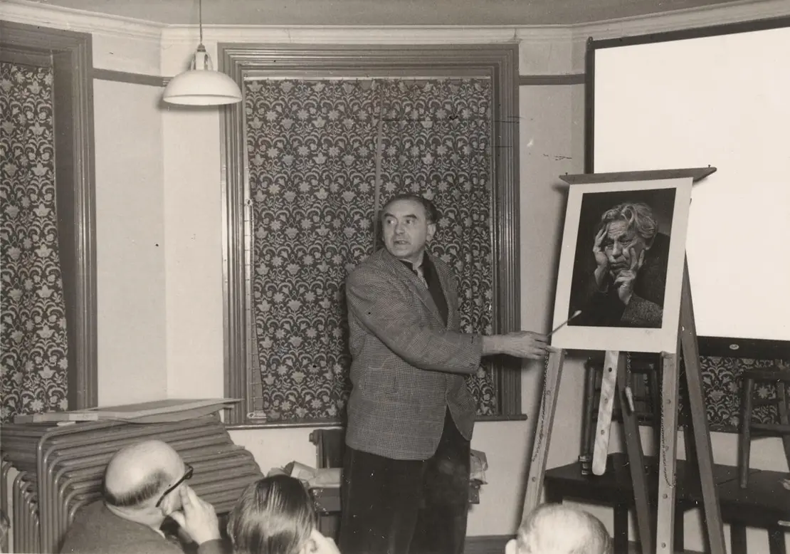 E. J. Shakespeare, Karl Pollak während eines Vortrages vor einer seiner Porträtfotografien, Silbergelatine, um 1960, Wien Museum, Inv.-Nr. 316530  