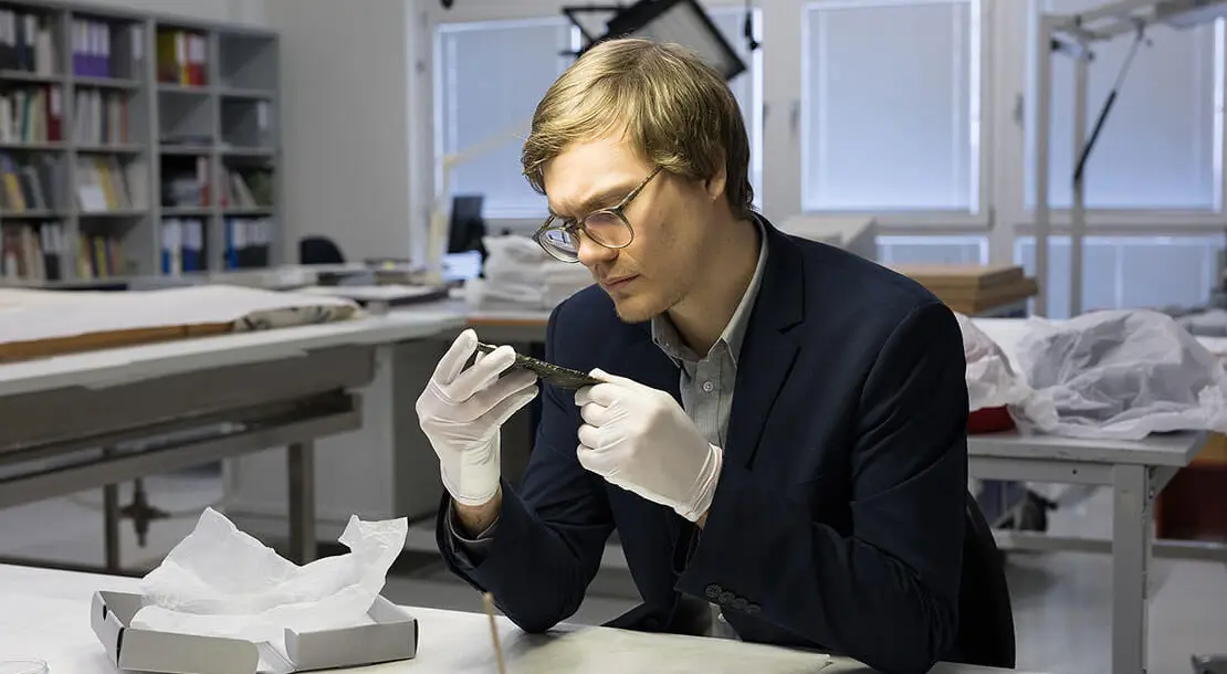 Der Historiker Niklas Rafetseder mit dem Fragment einer Inschrift, die er als Stadtrecht identifizieren konnte. Gefunden wurde das Bronzestück in Vindobona - ein deutlicher Hinweis darauf, dass Vindobona Stadtrecht innehatte. Foto: Lisa Rastl  
