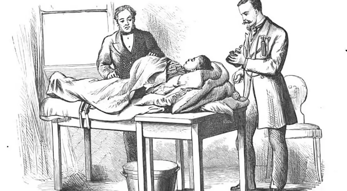 Abbildung aus Spencer Wells „Diseases of the Ovaries“, London, 1872. Bei der Vorbereitung zur Operation ist links der Chirurg Spencer Wells abgebildet, bei der rechten Person könnte es sich um Ferdinand Adalbert Junker von Langegg handeln, der sein Narkosegerät für den Einsatz vorbereitet. Quelle: Google Books   