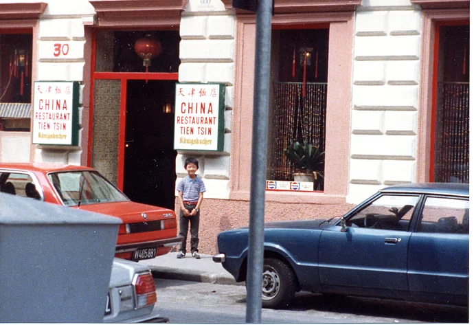 Jun Yang als Bub vor dem elterlichen Lokal „Tien Tsin“, um 1984, privat