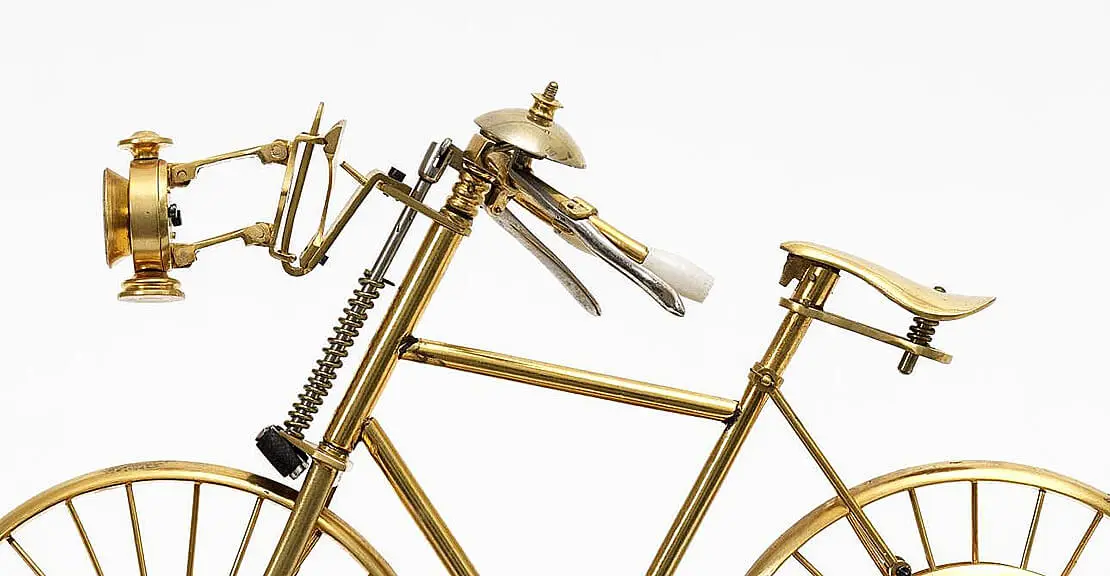 Detail: Fahrraduhr von Nicolaus mit Lampe, Bremse, Klingel, Spiralfeder im Sattel und an der Lenkstange.