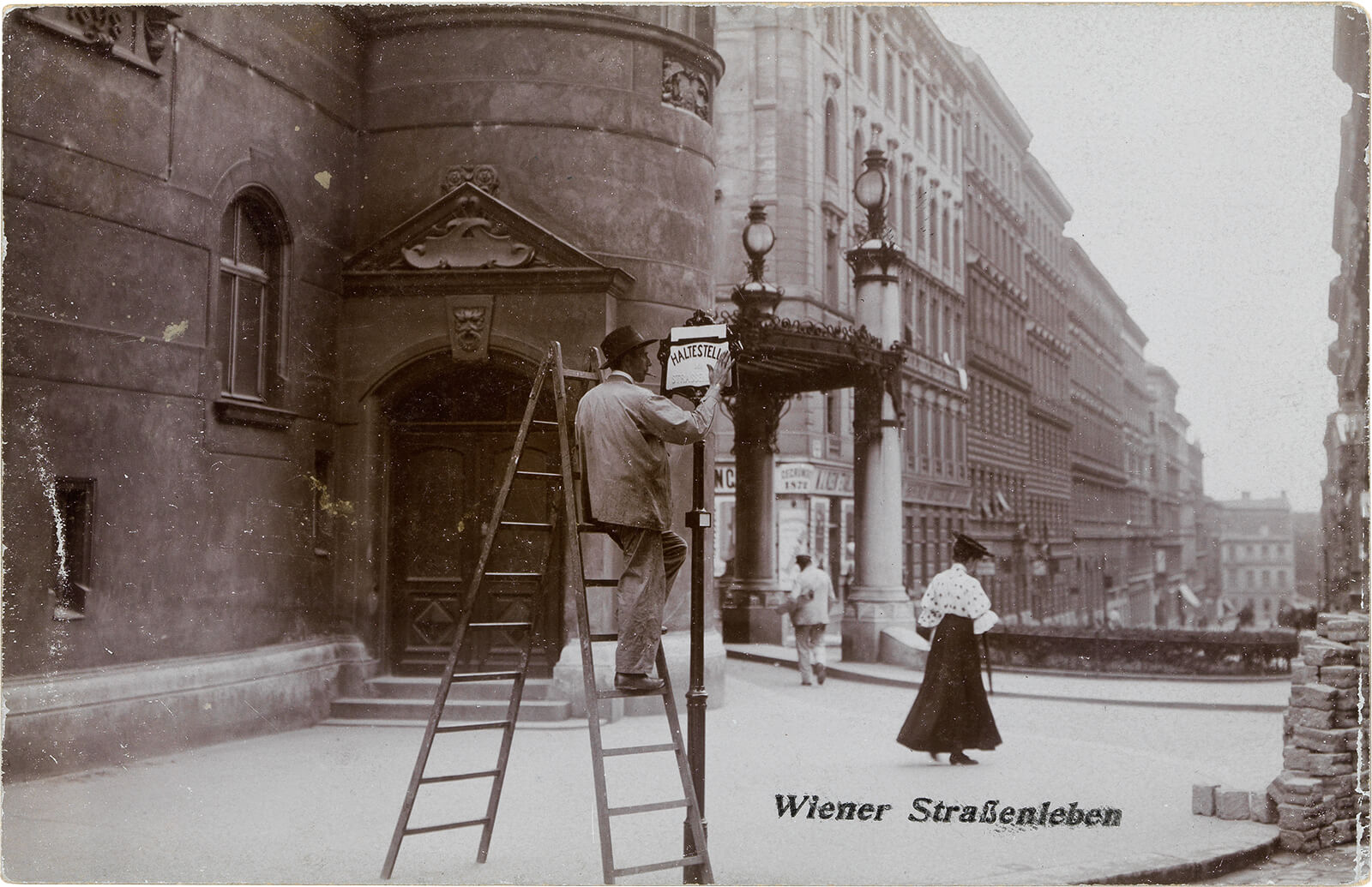 Anonyme:r Fotograf:in, Haltestellenmonteur vorm Kaiser-Jubiläums-Stadttheater (ab 1908: Volksoper), in der Ansichtskartenserie „Wiener Straßenleben", 1906/07, Glanzkollodiumpapier, Wien Museum 